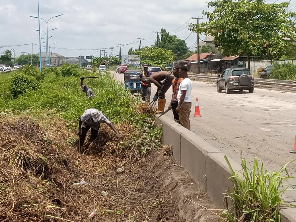 Environmental Health Officer, clears water obstructing vehicular movement along Warri - Effurun expressway